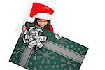 Festive little girl showing card against christmas wrapping paper with bow