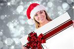 Festive blonde smiling at camera against red christmas ribbon
