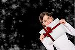 Cute little girl showing card against red christmas ribbon