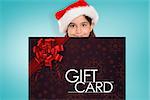 Festive little girl showing card against gift card with festive bow