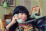 Beautiful 1960s style Caucasian woman on rotary telephone