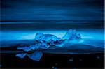 Blue Icebergs Washed up on Black Volcanic Sand Beach at Night, Iceland