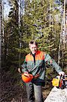 Portrait of man with chainsaw in forest