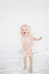 Little girl jumping on bed