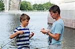 Father and son fishing at river
