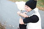 Mother hugging daughter on walk at autumn