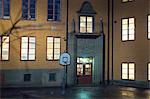 Basket hoop in front of school building at night