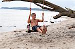 Mature man swinging on beach