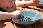 Boy eating milk with bilberries