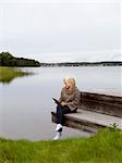 Smiling woman on jetty with digital tablet