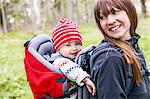 Smiling woman with baby in baby carrier