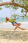 Young woman swinging at beach