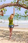 Young woman near swing at beach