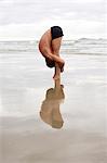 Man practicing yoga on beach