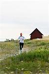 Young man running through meadow