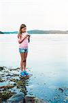 Girl with cell phone at water