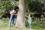 Mother with son playing near tree