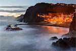 Illuminated town on rocky coast