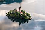 Lake Bled boat (Pletna) approaching Lake Bled Island at sunrise, Gorenjska, Slovenia, Europe