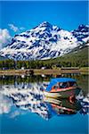 Scenic view of boat on lake and mountains in background, Ramfjord, Tromsoe, Troms, Northern Norway, Norway