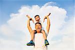 happy little boy  sitting on father's shoulder