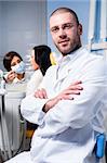 Friendly male dentist with assistant and patient at dental clinic