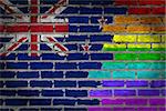 Dark brick wall texture - coutry flag and rainbow flag painted on wall - New Zealand