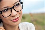 Portrait of a beautiful chinese asian young woman outside wearing glasses