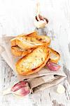 Garlic bread with fresh garlic on white wooden textured background. Culinary healthy eating, french country style.