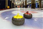 Curling stone on ice of an indoor rink