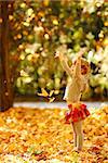 a beautiful little girl in the autumn park playing in nature