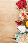 Healthy breakfast with muesli, berries and milk. On wooden table with copy space