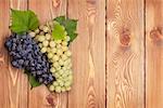 Bunch of red and white grapes on wooden table background with copy space