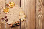 Christmas food decoration with gingerbread cookies, spices and candies. View from above on wooden background with paper for copy space