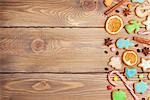Christmas wooden background with candies, spices, gingerbread cookies and copy space