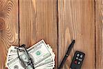 Money, glasses and car key on wooden table. View from above with copy space