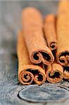 Cinnamon sticks in bucket on old wooden background