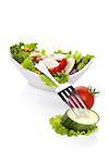 Delicious colorful vegetable salad. Fresh salad in bowl, fresh tomato and cucumber piece on fork isolated on white background. Healthy salad eating with copy space.