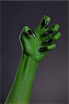 Green witch hand with sharp black nails, real body-art, Halloween theme