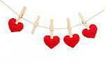 Red hearts with clothespins hanging on clothesline isolated on white background. Valentines Day