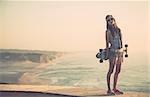 Beautiful and fashion young woman posing with a skateboard