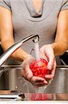 woman washing apples in the sink home kitchen