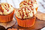 Carrot cupcakes decorated with cream cheese and caramel topping