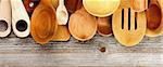 Border of Various Wooden Spoons and Cooking Utensils isolated on Rustic Wooden background. Horizontal View