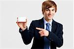 Young businessman showing a business card, over a gray background