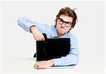 Young man in the office and pointing a gun to the laptop