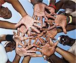 A group of mixed race people putting hands together