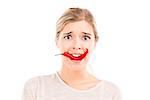 Beautiful girl making a silly face biting a red chilli pepper, isolated over a white background