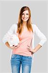 Beautiful woman holding a piggy bank, isolated over white background