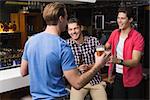 Young men drinking beer together at the bar